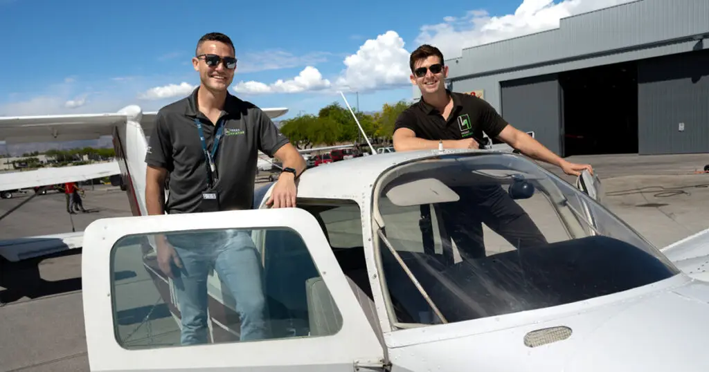 Two Vegas Aviation CFIs standing on each side of an aircraft