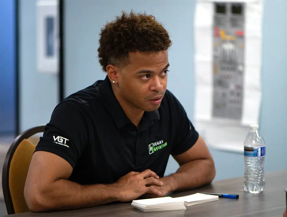 CFI with arms resting on a table paying attention to something