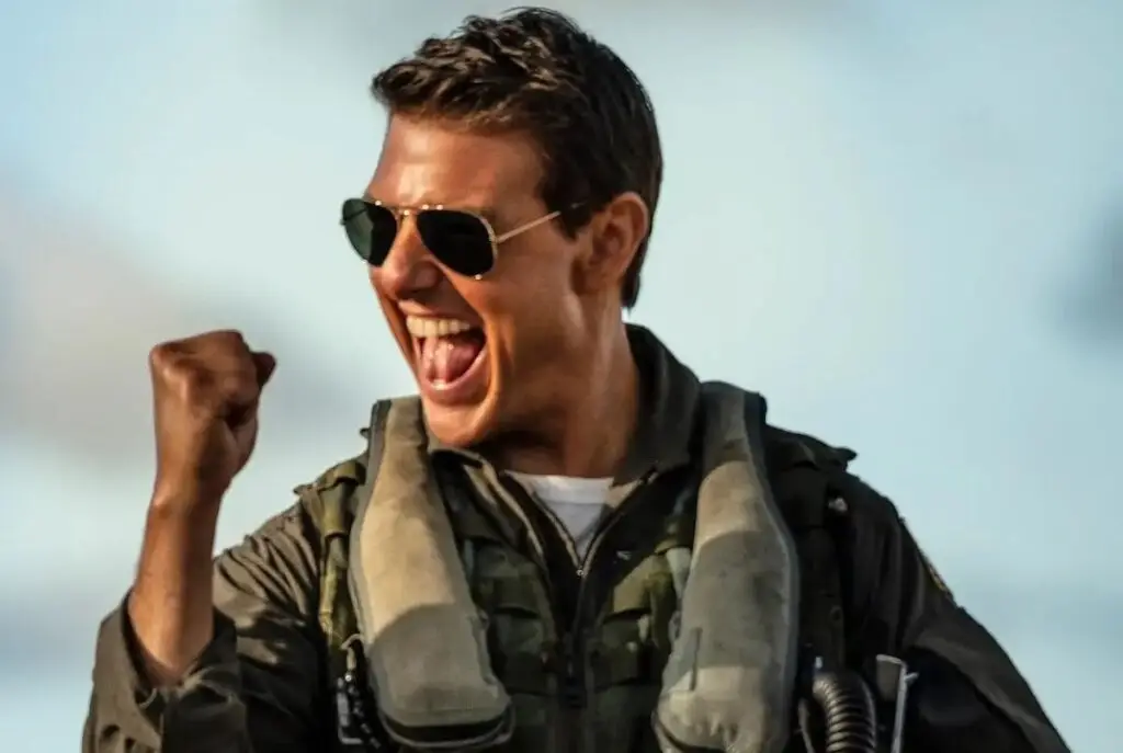 Tom Cruise a pilot uniform clenching his fist up in excitement