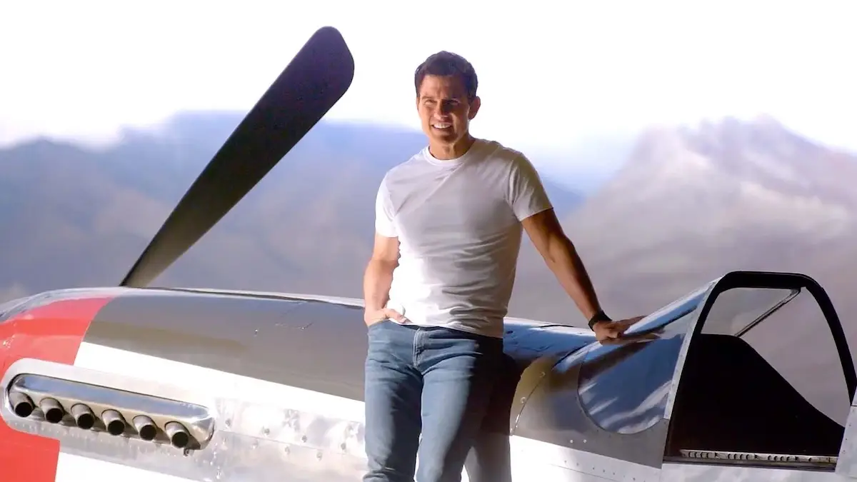 Actor Tom Cruise leaning on the left side of an aircraft