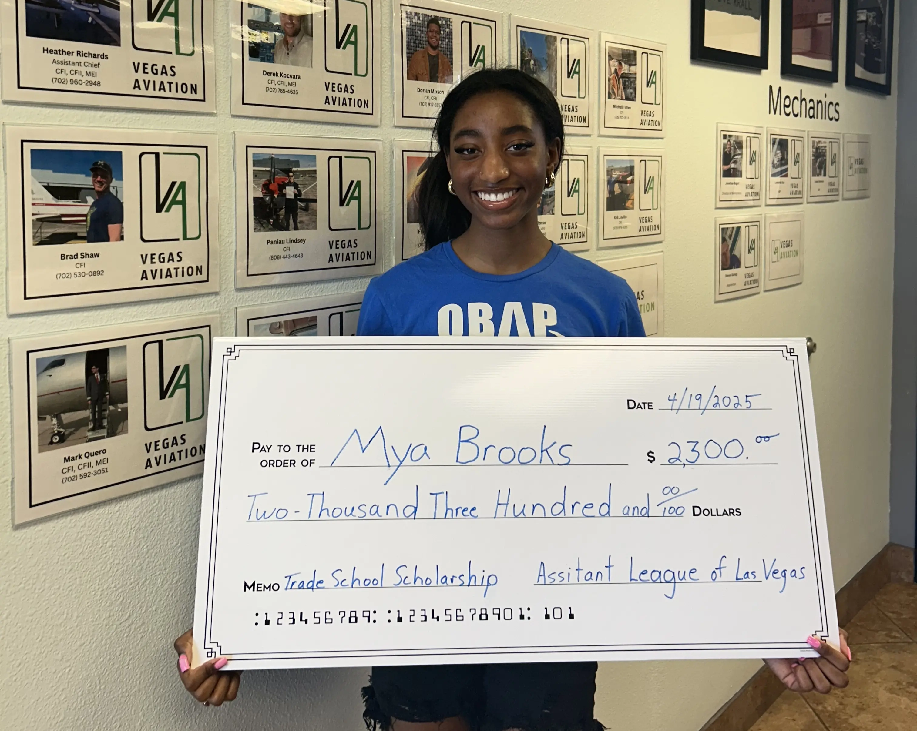 Mya Brooks holding a big check of two thousand and three hundred dollar scholarship